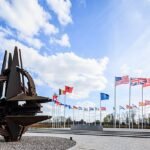 تندیس فلزی ناتو . در دورتر هم پرجم های اعضای ناتو