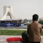 یک مرد پشت به تصویر دارد به میدان آزادی نگاه میکند