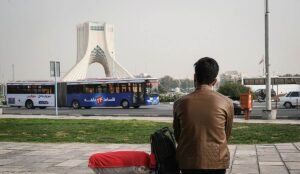 یک مرد پشت به تصویر دارد به میدان آزادی نگاه میکند