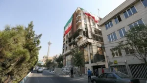 نمای دور از تهران که برج میلاد دیده می شود. در نمای نزدیکتر یک سمت ساختمان بلند تخریب شده و از سمت دیگر پرجم جمهوری اسلامی در ابعاد بزرگ نصب شده است