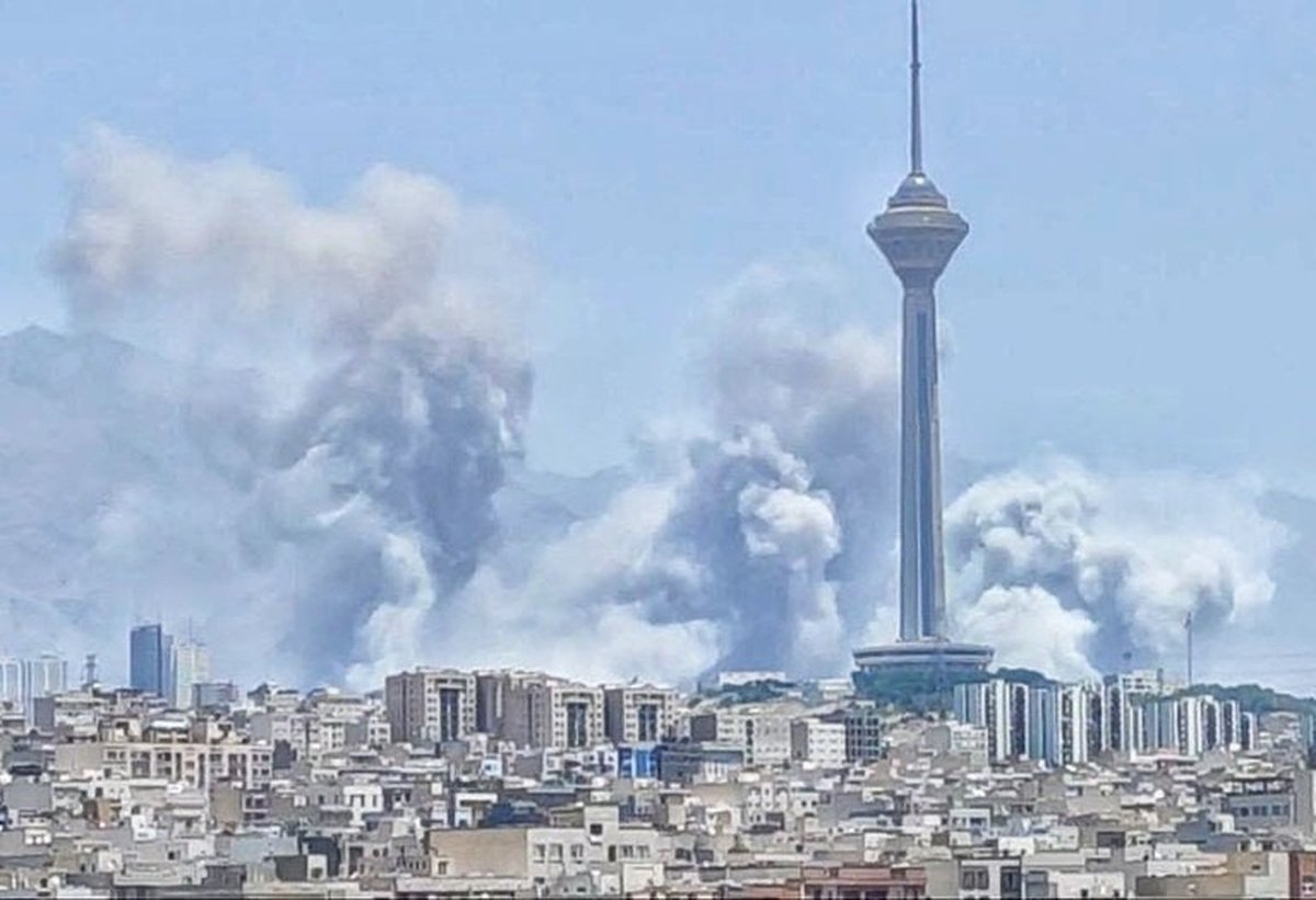 نمای دور از بمباران تهران که در آن برج میلاد دیده می شود و دورتر از آن دود به آسمان بلند شده است
