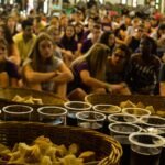 تعداد زیادی زن و مرد نشسته اند و آماده اند تا مراسم نان و شراب مقدس بخورند