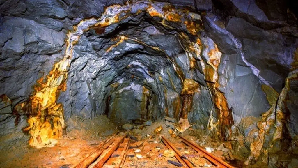 یک تونل تاریک که در ان رگه هایی از طلا دیده می شود