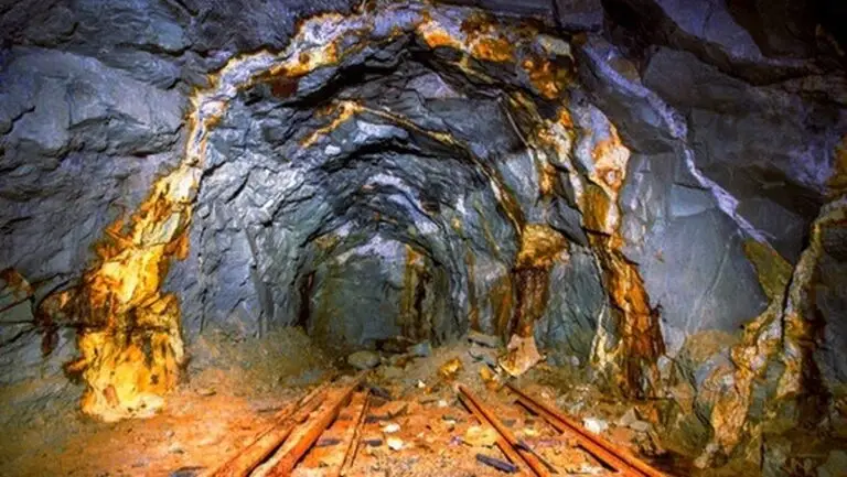 یک تونل تاریک که در ان رگه هایی از طلا دیده می شود