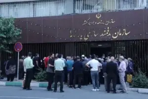 در روبروی سازمان هدفمندی یارانه ها حدود چهل نفر زن و مرد ایستاده اند. به نظر می رسد اعتراض دارند