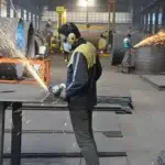 یک سنعتکار در حال کار با دستگاه سنگ فرز