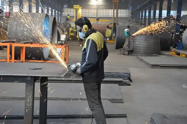 یک سنعتکار در حال کار با دستگاه سنگ فرز