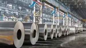 ورقه های لوله شده و بزرگ آلومینویم در یک انبار بزرگ که در کنار هم هم قرار گرفته است