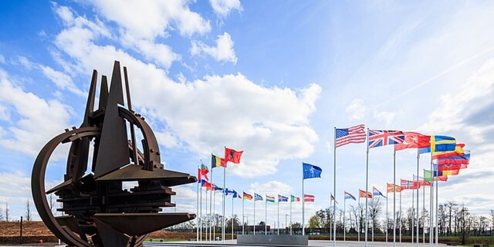 تندیس فلزی ناتو . در دورتر هم پرجم های اعضای ناتو