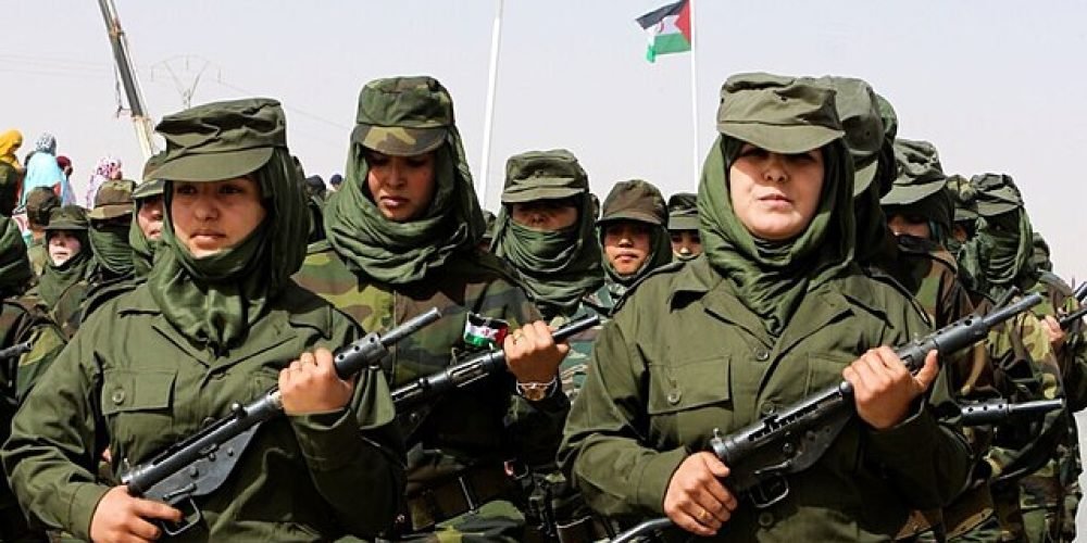 تعدادی زن با لباس نظامی و اسلحه در درست در حال رژه رفتن هستند. زن ها چریک های جبهه پولیساریو هستند.