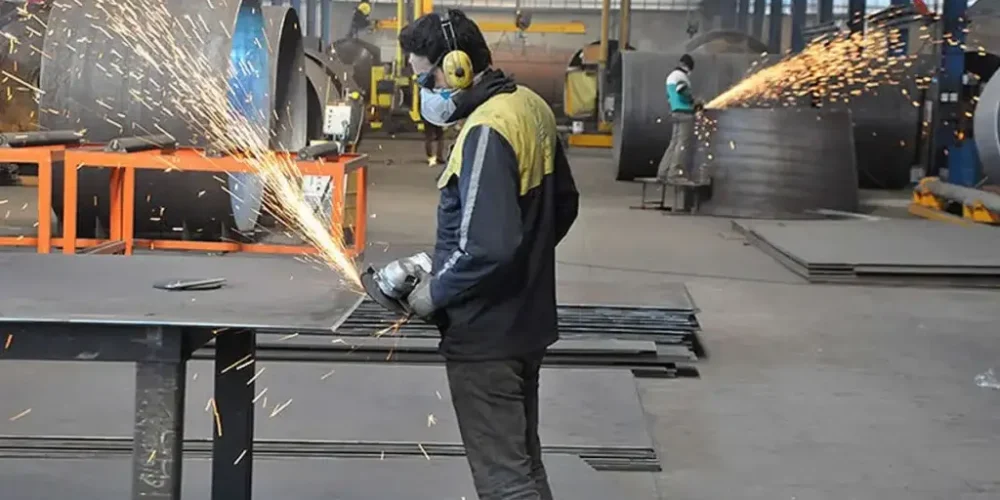 یک سنعتکار در حال کار با دستگاه سنگ فرز