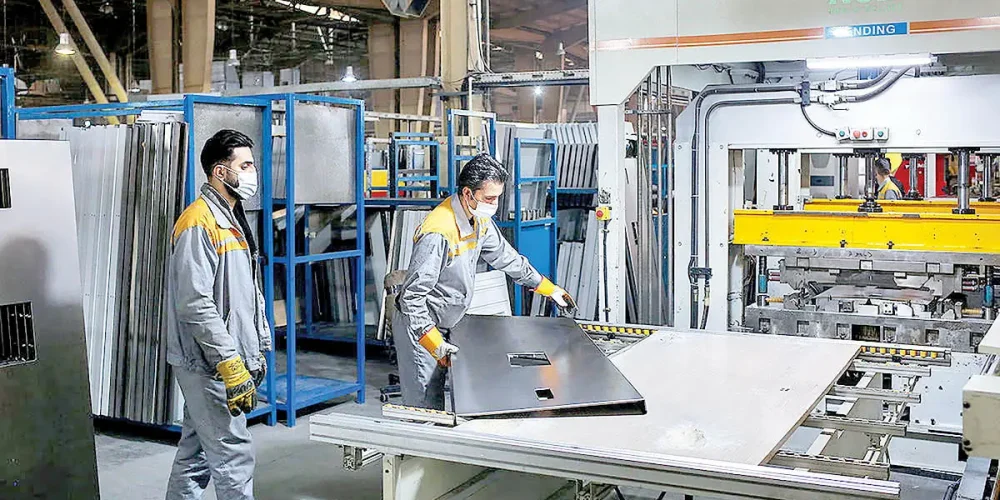 دو کارگر مرد در حال کار کردن در یک کارگاه صنعتی آلومینوم